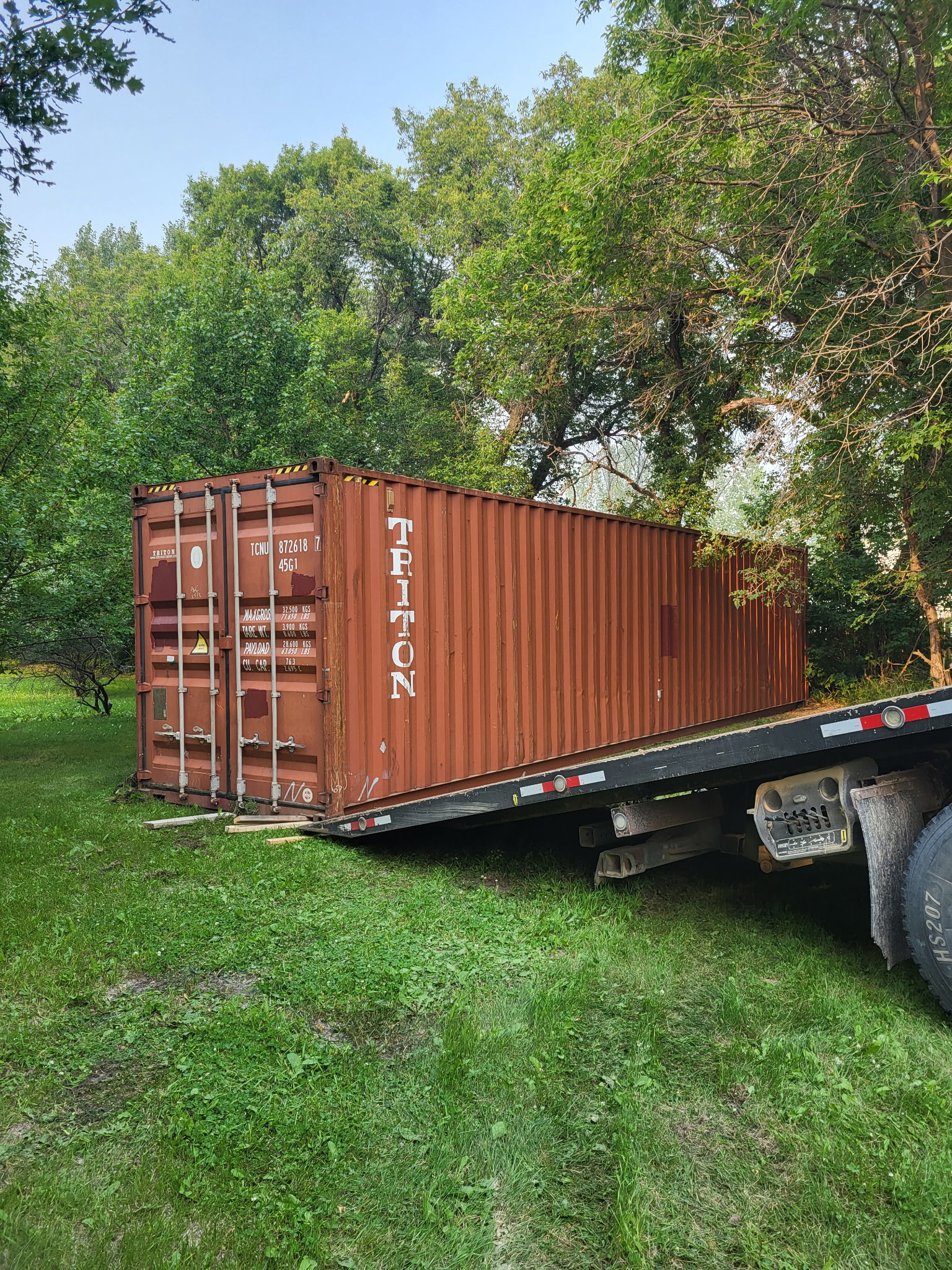 Seacan being loaded in tough treed area